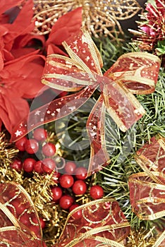 Traditional Christmas background. Red berries, ribbons and leaves in foreground