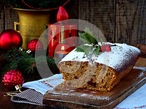 Traditional Christmas fruit cake decorated with powdered sugar and mas decorations, candle. copy space. style rustic. selective fo