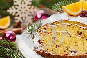 Traditional Christmas fruit cake with orange and dried cranberry decorated fir tree and icing sugar