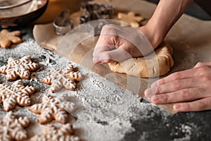 Traditional Christmas homemade cookie baking. Man& x27;s hands kneading dough on table with flour and gingersnaps. Soft photo