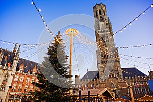 Traditional Christmas market in Europe, Bruges, Belgium. Main town square with decorated tree and lights