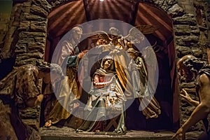 Traditional Christmas nativity scene with beautiful figures made out of wood. The birth of Jesus Christ in the manger surrounded