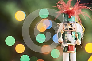 Traditional Christmas nutcracker with out of focus colored light background