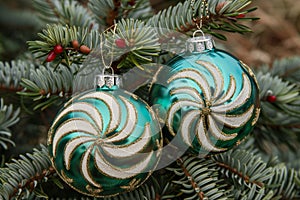 Traditional christmas ornaments and candy decorations hanging on lush green fir tree