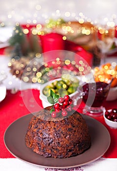 Traditional Christmas pudding with holly on top on a Christmas dinner.