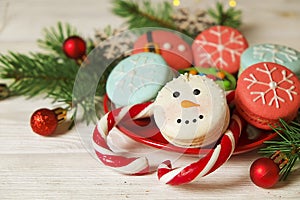 Traditional christmas themed french macaroons sweets in the form of snowman, snowflake, christmas tree and santa`s belly with can