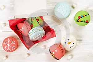 Traditional christmas themed french macaroons sweets in the form of snowman, snowflake, christmas tree and santa`s belly with can