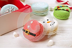 Traditional christmas themed french macaroons sweets in the form of snowman, snowflake, christmas tree and santa`s belly with can