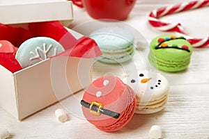 Traditional christmas themed french macaroons sweets in the form of snowman, snowflake, christmas tree and santa`s belly with can