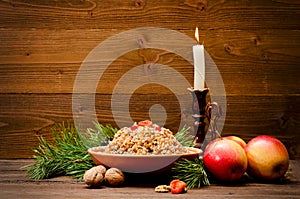 Traditional Christmas treat of the Slavs on Christmas eve kutia. Fir branch, apples, candle on wooden background