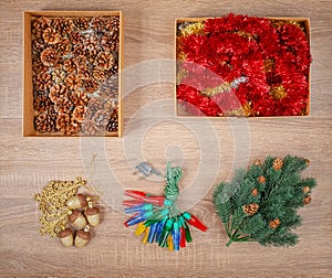 Traditional christmas tree decorations including baubles, fir cones, garland lights, glitter garland.