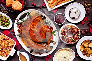 Traditional Christmas turkey dinner. Top view table scene on a dark wood background.