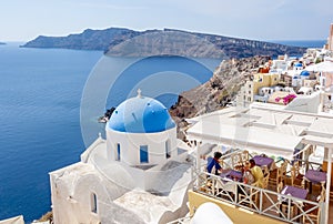 Traditional church and cafe in Oia village, Santorini island, Greece