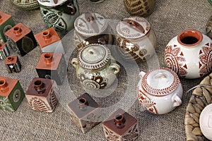 Traditional clay pots with enamel on a table covered with burlap