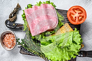 Traditional club sandwiches with turkey ham, cheese, tomatoes and lettuce. White background. Top view