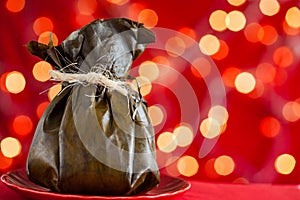 Traditional Colombian tamale as made on Tolima region over a christmas red background photo