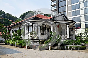 Traditional colonial house Singapore next to modern highrise building