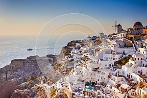 Traditional Colorful Houses and Windmills of Oia or Ia at Santorini Island with Yacht in Background at Noon