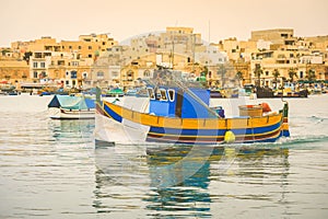 Traditional colourful boats in the harbour of fishing village in Malta
