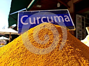 Traditional colourful spiecies in a typical exotic moroccan suk market. Curcuma turmeric writing photo