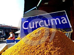Traditional colourful spiecies in a typical exotic moroccan suk market. Curcuma turmeric writing photo