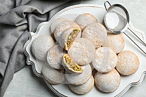 Traditional cookies for Islamic holidays and strainer with powdered sugar on table, top view