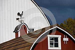 Traditional coper rooster weathervane on a classic red barn cupola, wifi antenna installed on front of barn