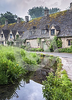 Traditional cotswold stone cottages built of distinctive yellow limestone in the famous Arlington Row, Bibury Gloucestershire UK