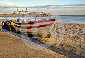 Traditional crab fishing boat moored on the beach at Cromer during sunrise