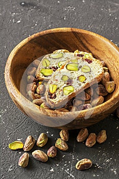 Traditional crispy Italian biscotti or cantuchini crackers with pistachios and dried cranberries in a bowl of olve wood