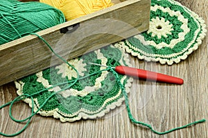 Traditional crochet oven gloves made of green and beige wool