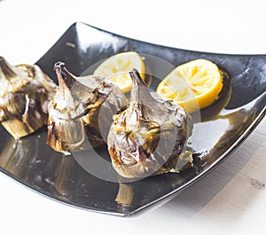 Traditional cuisine: artichokes cooked in the oven with oil and lemon photo