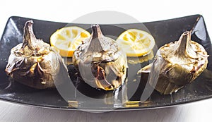 Traditional cuisine: artichokes cooked in the oven with oil and lemon photo