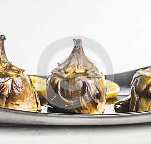 Traditional cuisine: artichokes cooked in the oven with oil and lemon photo