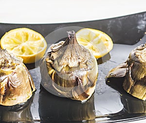 Traditional cuisine: artichokes cooked in the oven with oil and lemon photo