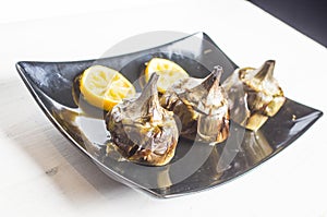 Traditional cuisine: artichokes cooked in the oven with oil and lemon photo