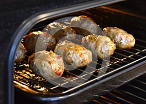 Traditional Cypriot food. Sheftalia : Cypriot Lamb and Pork Sausages on a metal grill being cooking in the oven.