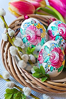 Traditional Czech easter decoration - colorful painted eggs in wicker nest with pussycats