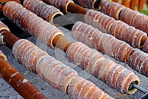 Traditional Czech food `Trdelnik`. A popular dish among tourists to prepared on a wooden skewers over hot coals