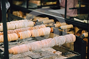 Traditional Czech sweet treat Trdelnik. On a special wooden skewers over hot coals. A popular dish among tourists.