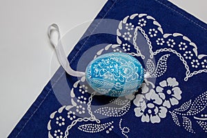 Czech easter egg lying on a blue scarf. photo