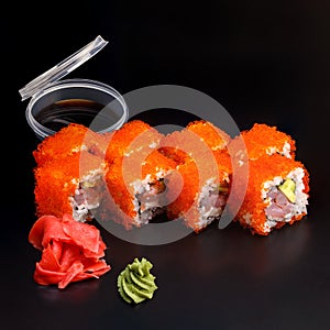 Traditional delicious fresh California King sushi roll set on a black background with reflection