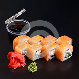 Traditional delicious fresh sushi roll set on a black background with reflection