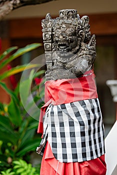 Traditional demon guard statue carved in stone in Bali island.