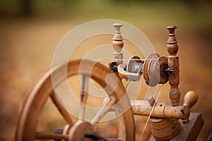 Traditional devices, vintage tailoring equipment concept. Old fashioned wooden distaff, spindle, spinning wheel. Old fashioned