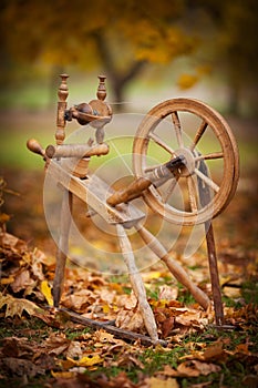 Traditional devices, vintage tailoring equipment concept. Old fashioned wooden distaff, spindle, spinning wheel. Old fashioned