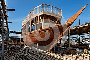 Traditional dhow under construction in wharf in Sur, Oman photo