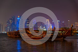 Traditional dhows with skyline of Doha in Qatar during night