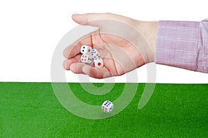 Traditional dice in male hand over table with green cloth