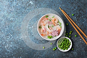 A traditional dish of Asian cuisine. Rice vermicelli with shrimps, bebe octopus and green peas